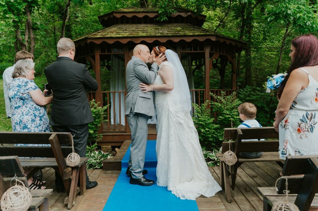 Bride and groom kissing at outdoor alter.