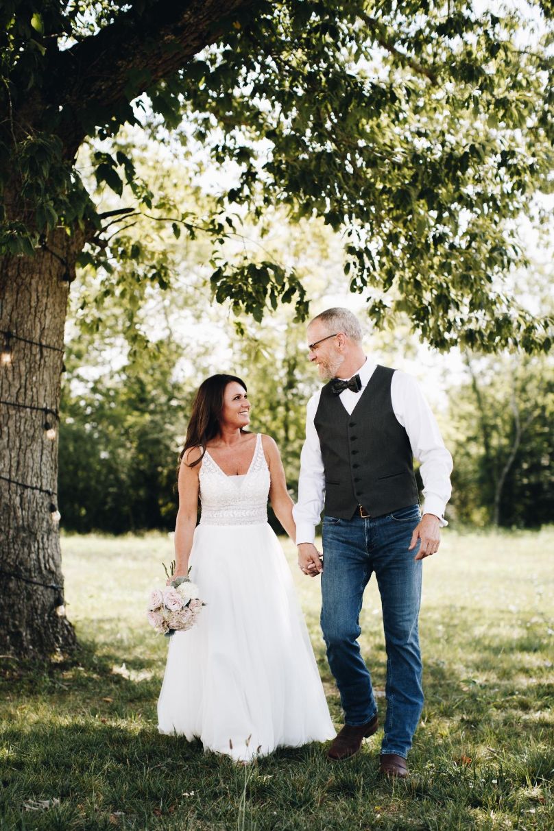 Bride and groom holding hands.