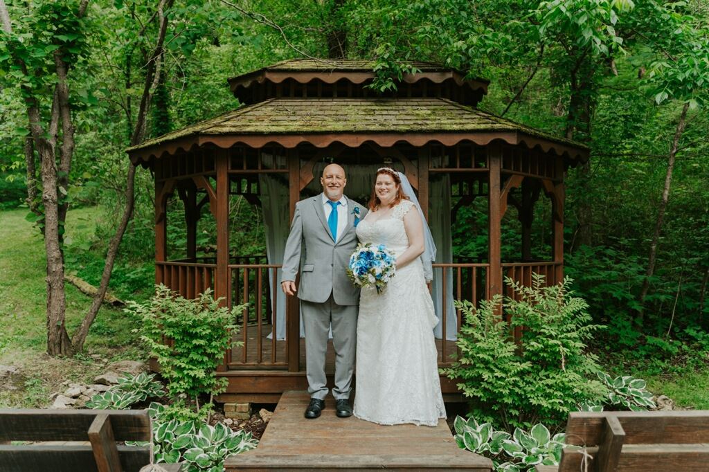 Bride and groom outdoor portrait in front of a gazebo.