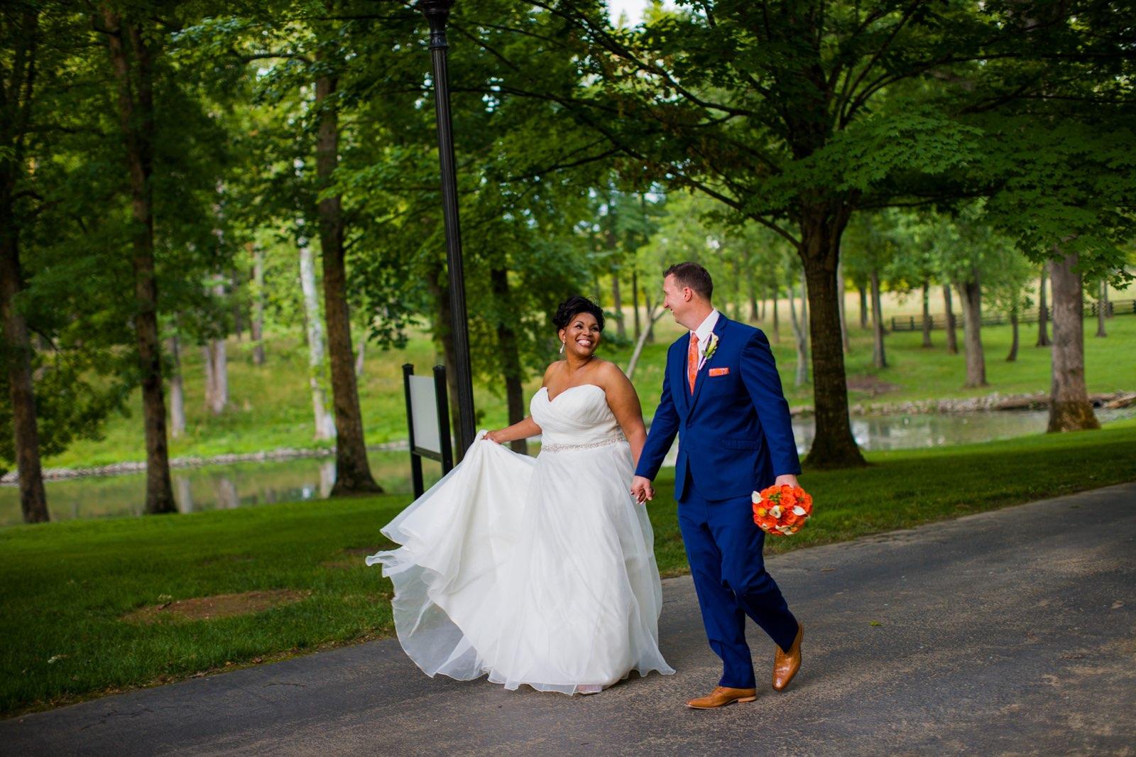 Bride and groom walking and holding hands.